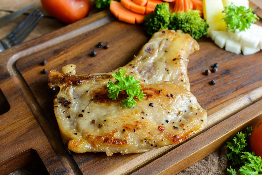 Kurobuta pork chop steak on rustic wooden table